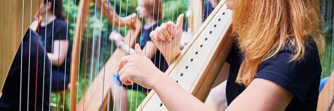 Frauen spielen Harfe