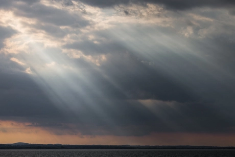 Sonnenstrahlen brechen durch die Wolken.