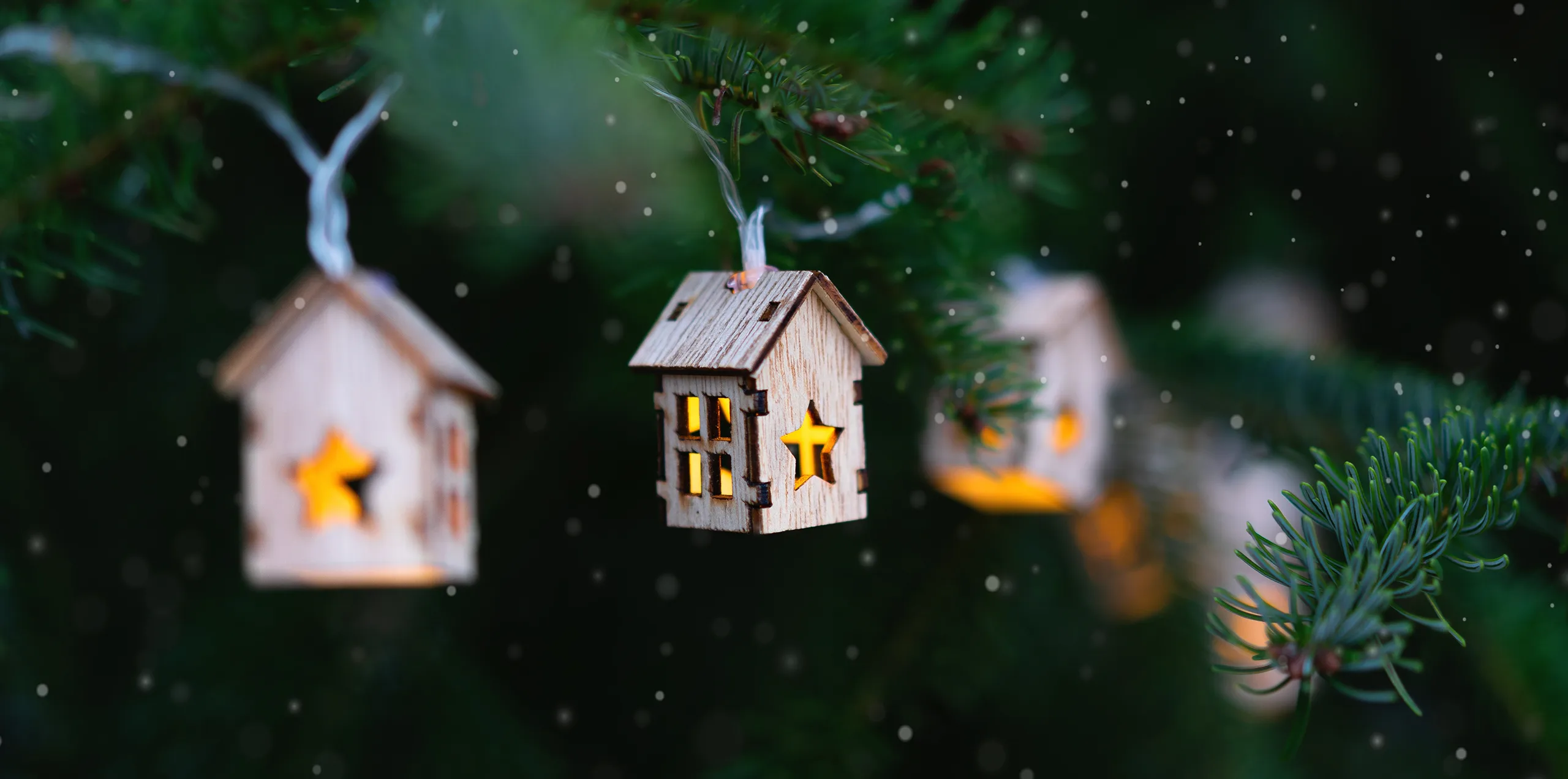 hängende Lichter-Holzhäuschen auf einem Tannenbaum