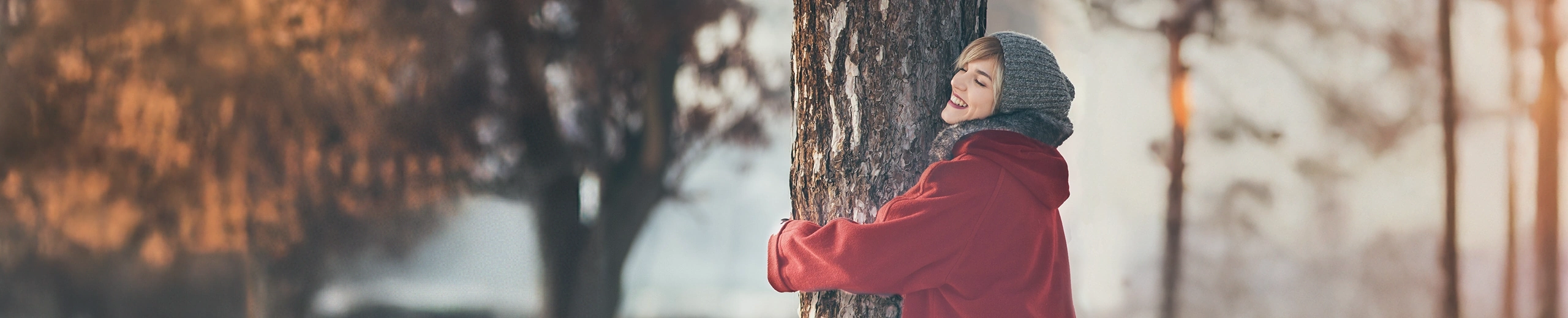 eine Frau umarmt einen Baum