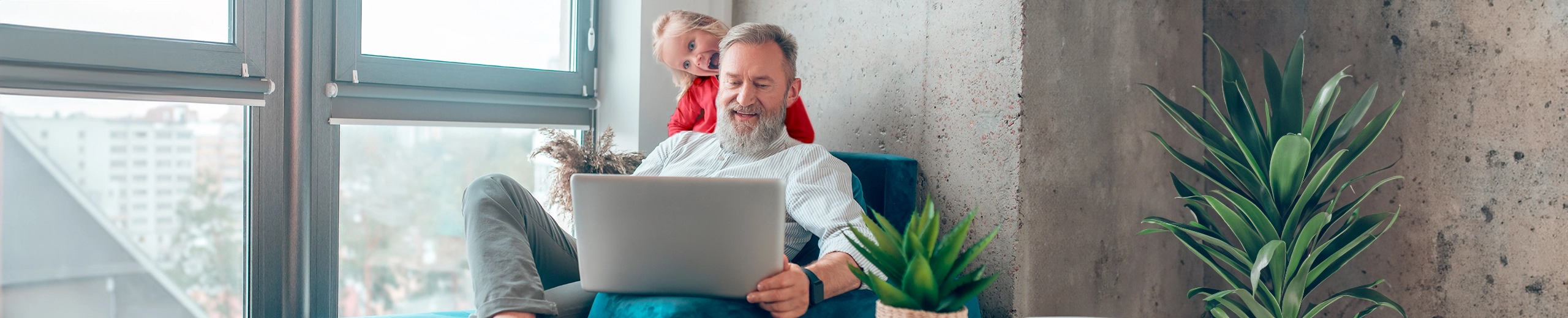 ein Großvater mit seinem Enkelkind vor dem Laptop