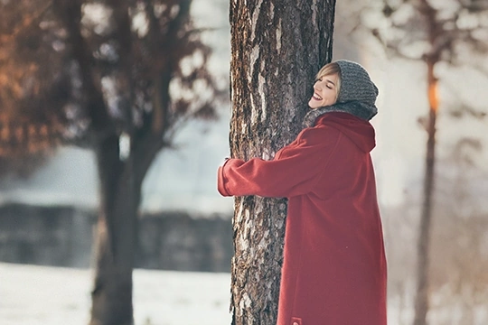 eine Frau umarmt einen Baum