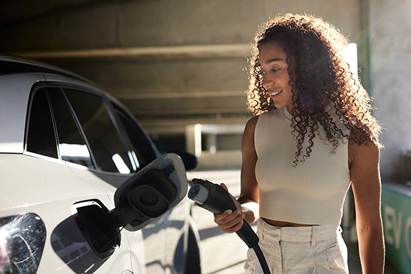 Eine Frau lädt ihr E-Auto auf