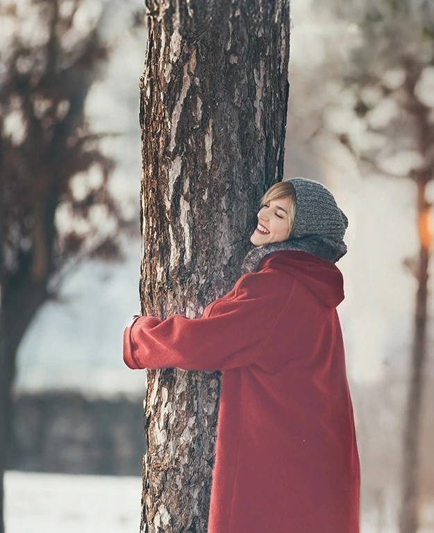 eine Frau umarmt einen Baum