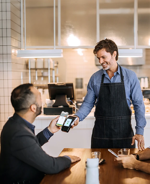 Ein Mann bezahlt in einem Restaurant mit Apple Pay