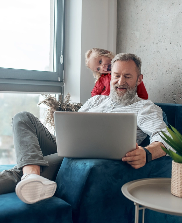 ein Großvater mit seinem Enkelkind vor dem Laptop