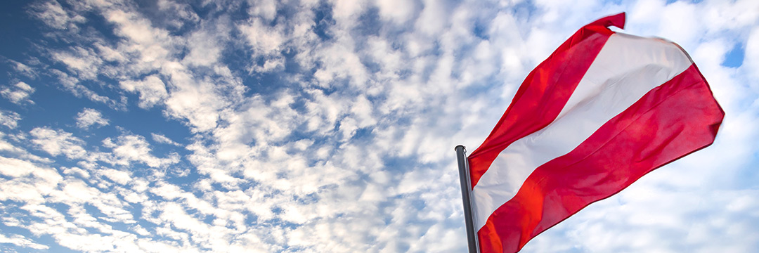 Die österreichische Flagge vor dem bewölkten Himmel