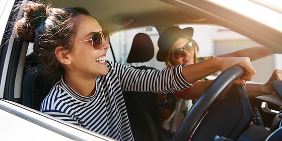 Zwei junge Frauen fahren mit einem Auto