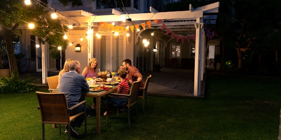 Eine Familie im Garten ihres Hauses bei Nacht