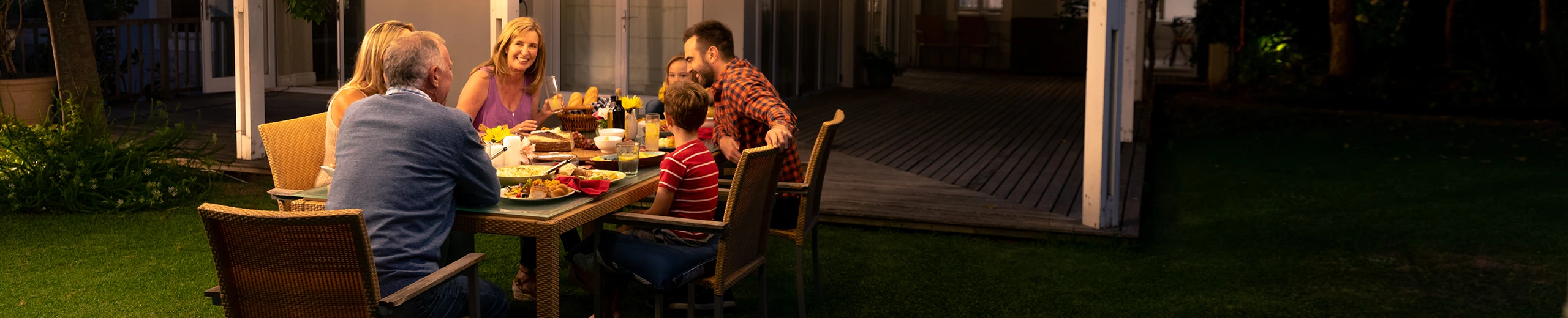 Eine Familie sitzt im Garten ihres Hauses