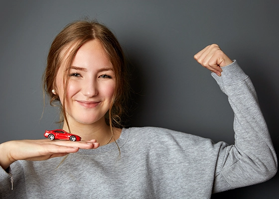 Ein Mädchen mit einem Spielzeugauto am Arm