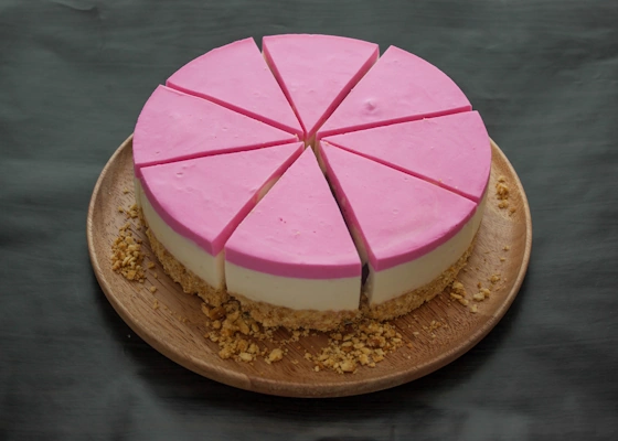 eine in Stücke geschnitte Torte mit rosa Deckplatte