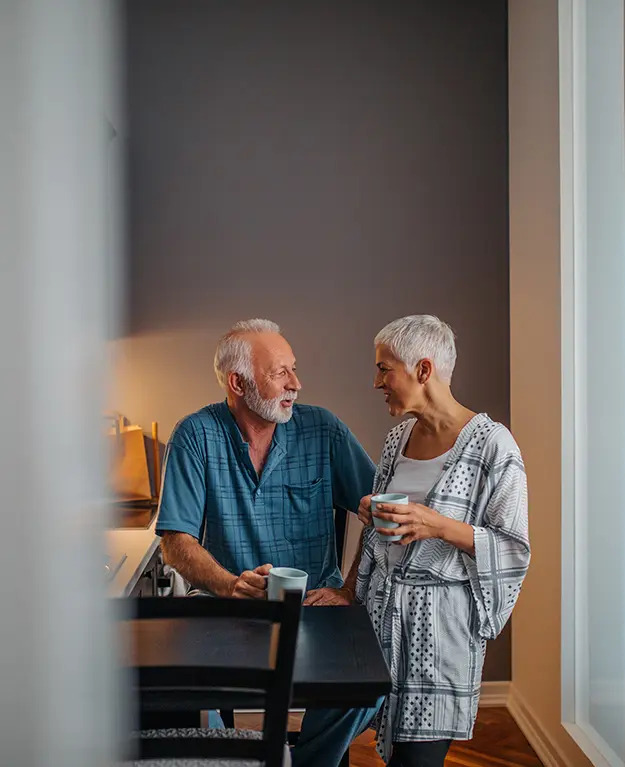 Ein älterer Mann und eine ältere Frau trinken gemeinsam einen Kaffee