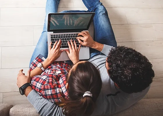 Ein Paar sitzt gemeinsam vor dem Laptop