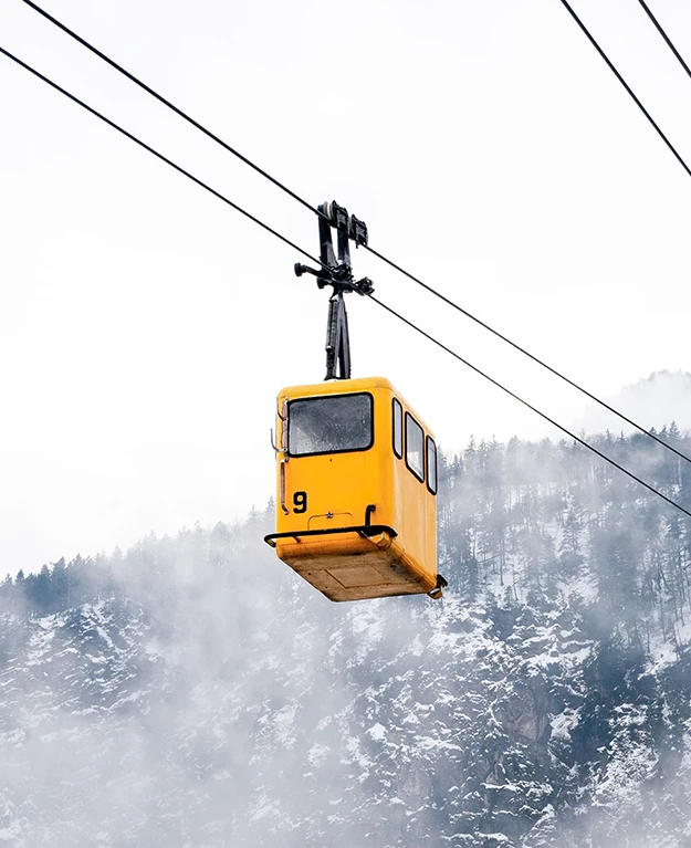 a yellow gondola emerges from the fog