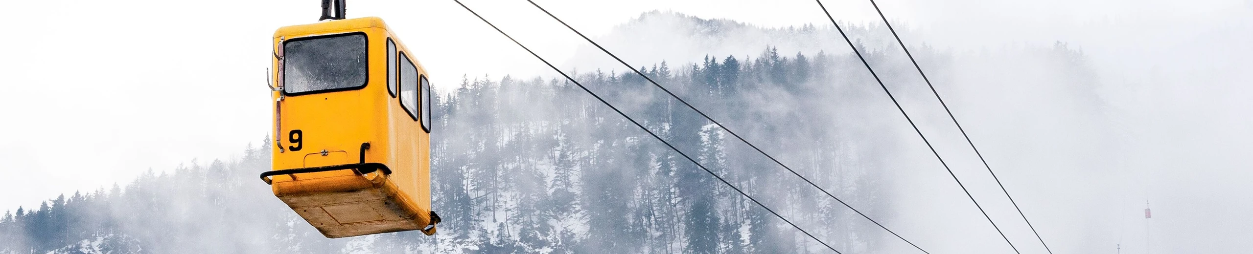 a yellow gondola emerges from the fog