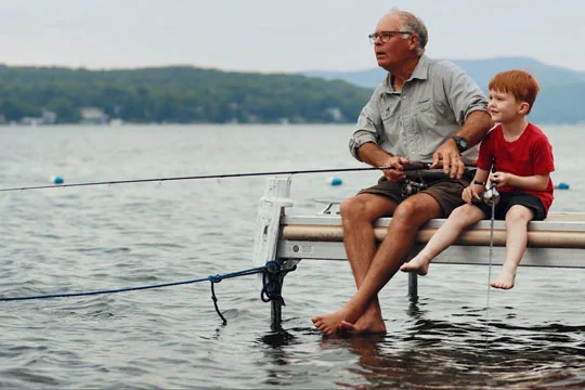 A grandfather with his grandson fishing on a jetty