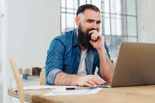 Ein Mann sitzt vor seinem Laptop