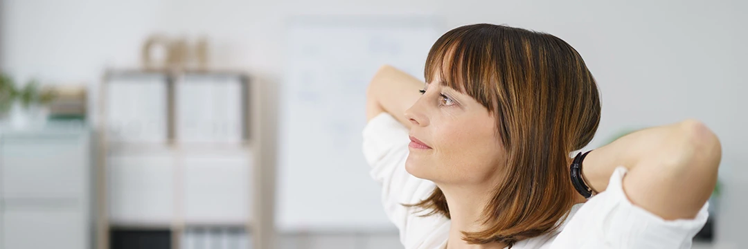 Eine junge Frau hat die Hände hinter dem Kopf gefalten