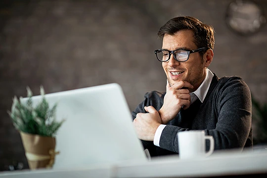 Mann sitzt vor dem Laptop