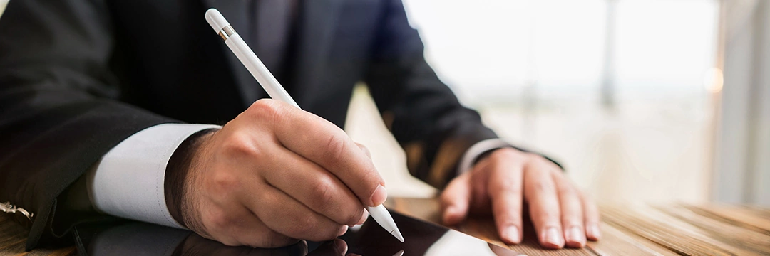 Ein Mann schreibt mit einem Stift auf einem Tablet