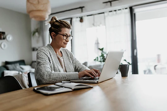 Eine Business Frau sitzt vor ihrem Laptop