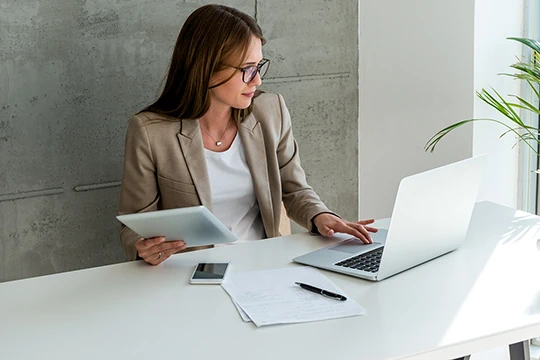 Frau sitzt vor Laptop und arbeitet