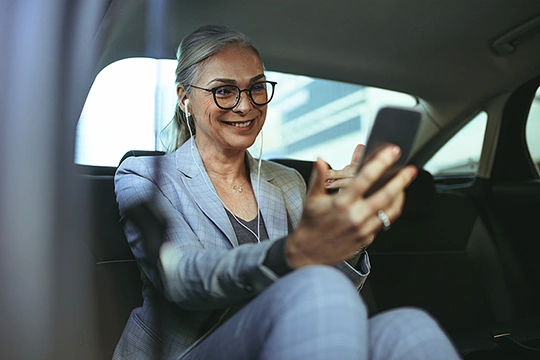 Frau mit Handy im Auto