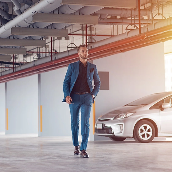 Ein mann in einem Parkhaus, geht von seinem Auto weg