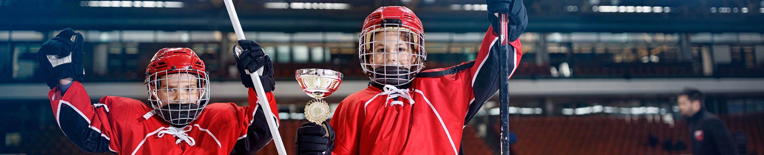 Zwei junge Eishockeyspieler mit einem Pokal in der Hand