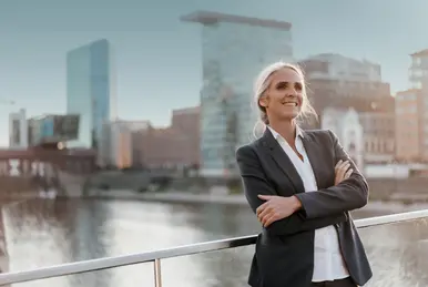 Eine Frau vor einer Brücke und Häusern im Hintergrund