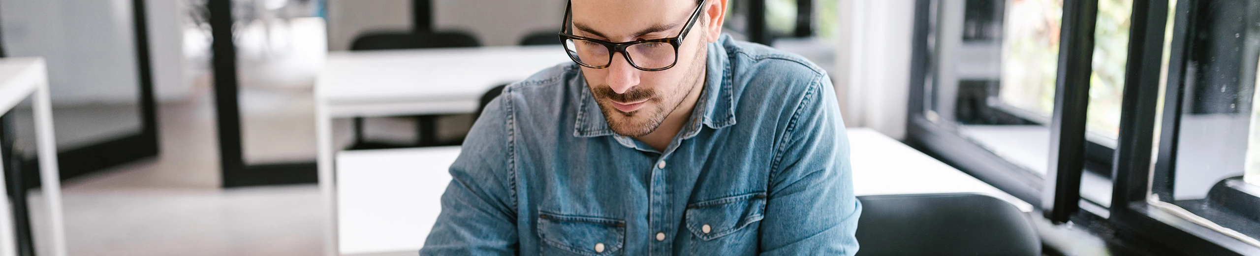 man writing on paper on his desk