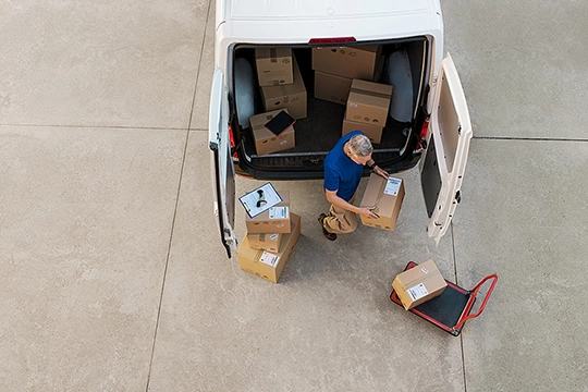 A man unloads packages from a van