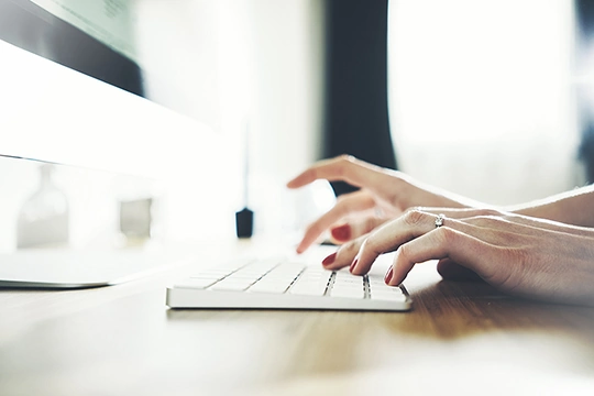 Close up of female hands typing on computer keyboard