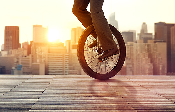 Someone rides a unicycle in the sun