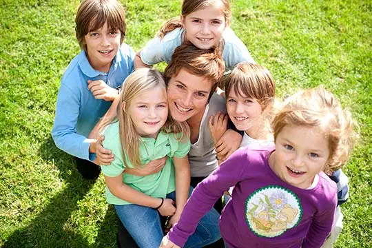 Eine Gruppe Kinder sitzt im Gras