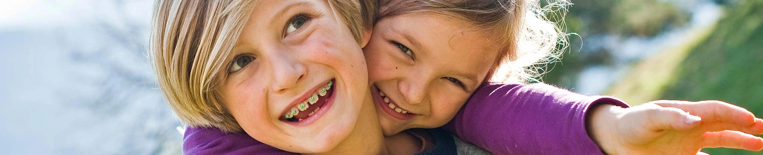 Mädchen sitzt auf dem Rücken eines Jungen, beide lachen