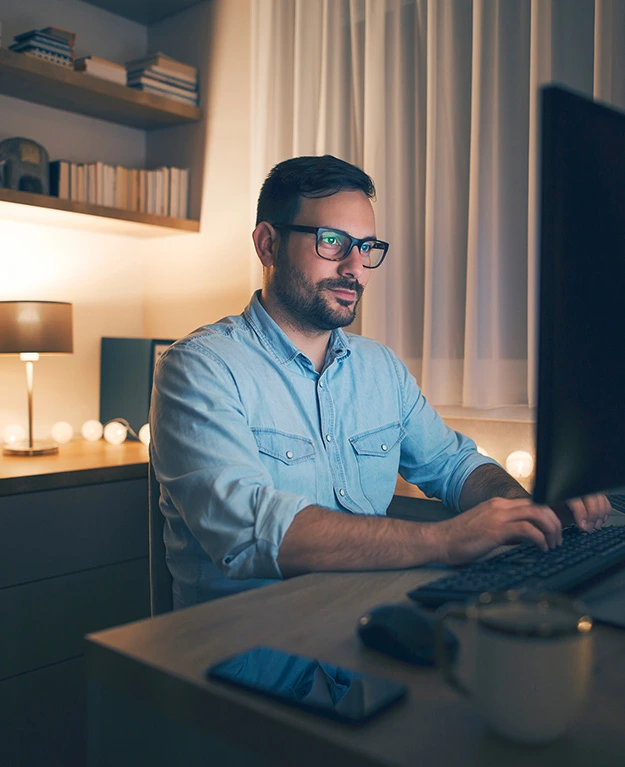 Ein Mann sitzt hinter seinem Computerbildschirm