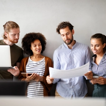 4 people side by side looking at documents