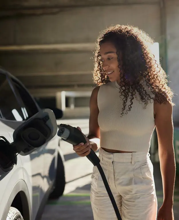 Eine Frau lädt ihr E-Auto auf