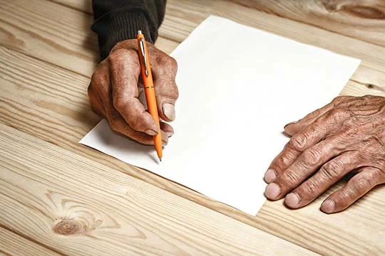 Hände über einem leeren Blatt Papier mit einem Kugelschreiber in der Hand