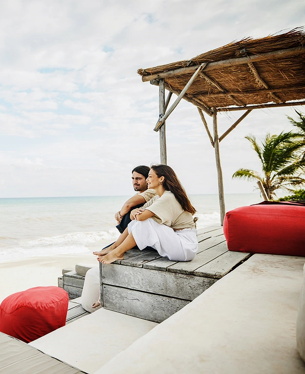 A couple sits on a terrace and looks at the sea