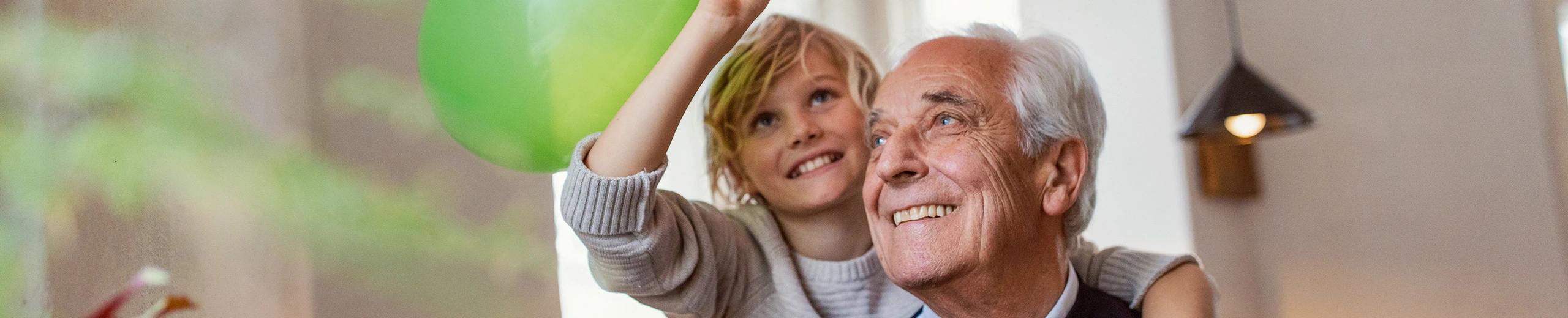 Ein Großvater mit seinem Enkelkind mit Luftballons