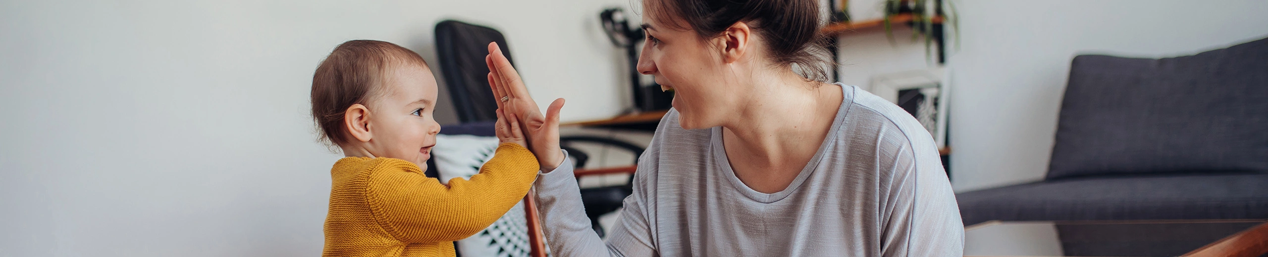 Eine Mutter mit ihrem kleinen Kind, sie klatschen sich in die Hände