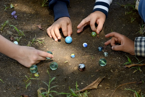 Kinder spielen mit Murmeln