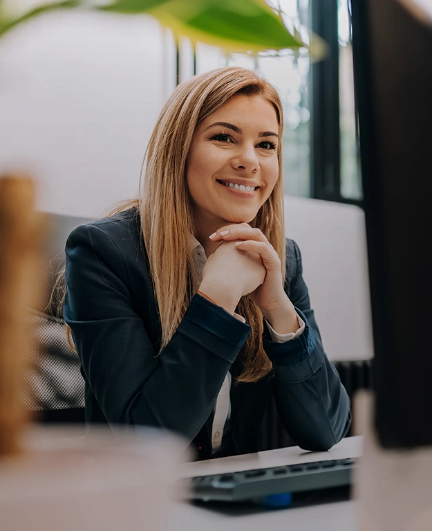 A woman sits in front of the computer