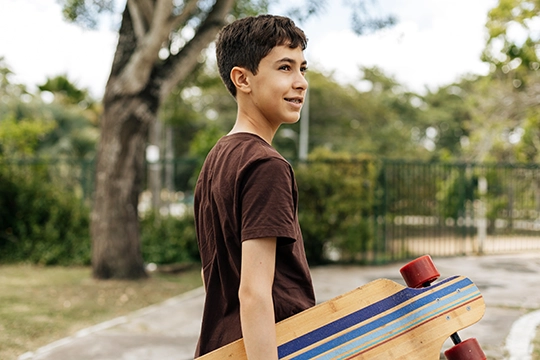 Junge mit Skateboard im Park