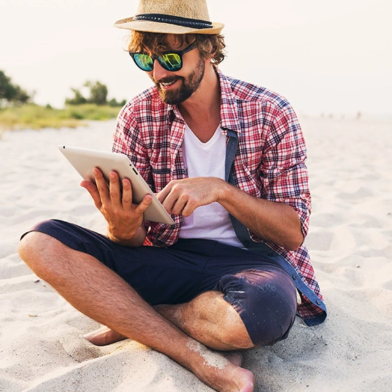 A man with a tablet on the beach