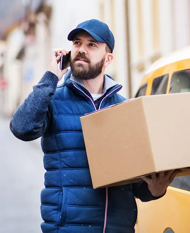 Mann telefoniert und liefert ein Paket aus