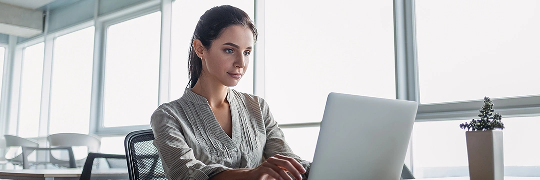 Eine junge Frau sitzt vor dem Laptop